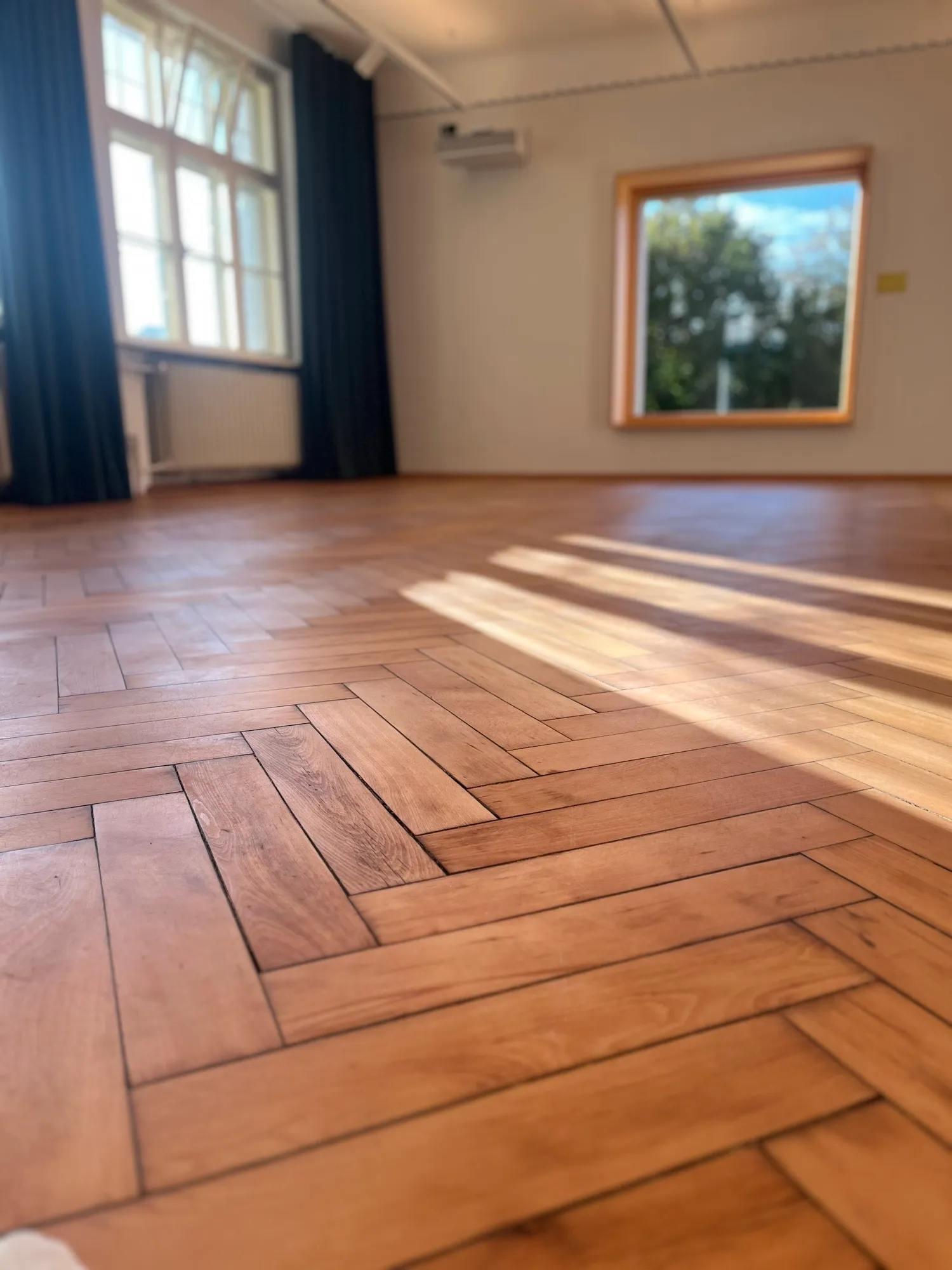 Der Dorfsaal der Alten Schule Bühl mit Holzboden in der Sonne